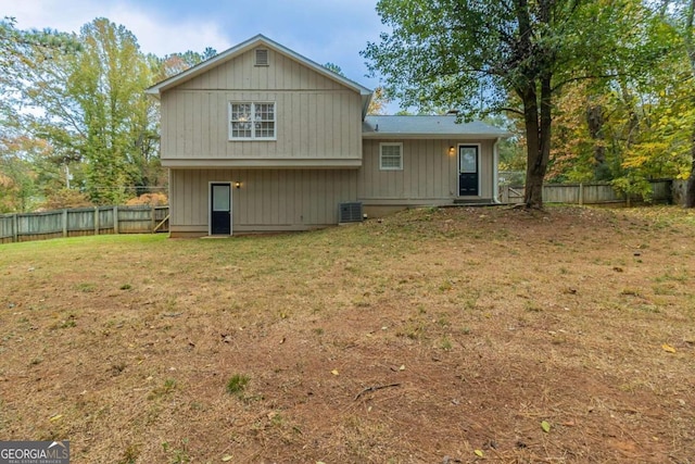 back of house with a lawn and central AC