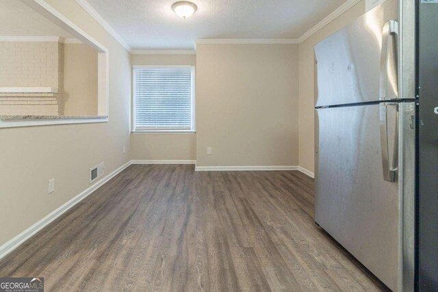 kitchen featuring ornamental molding, hardwood / wood-style floors, and stainless steel fridge