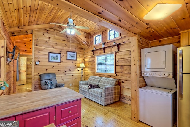 office area with stacked washer and clothes dryer, wood walls, lofted ceiling, wooden ceiling, and light hardwood / wood-style flooring