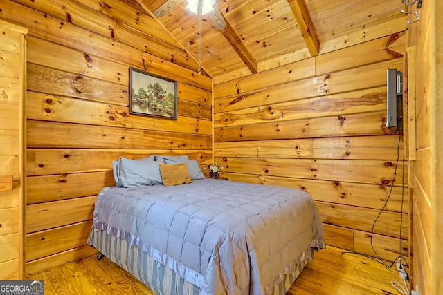 bedroom with lofted ceiling with beams, light hardwood / wood-style flooring, wooden walls, and wood ceiling