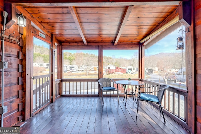 sunroom with a mountain view, beamed ceiling, and wooden ceiling