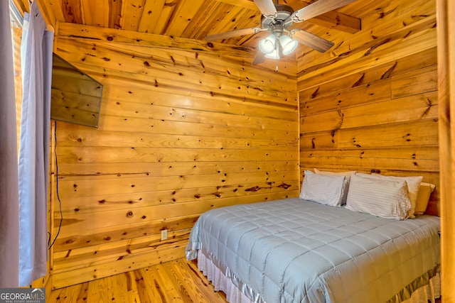 bedroom featuring wood walls, light wood-type flooring, wood ceiling, and ceiling fan