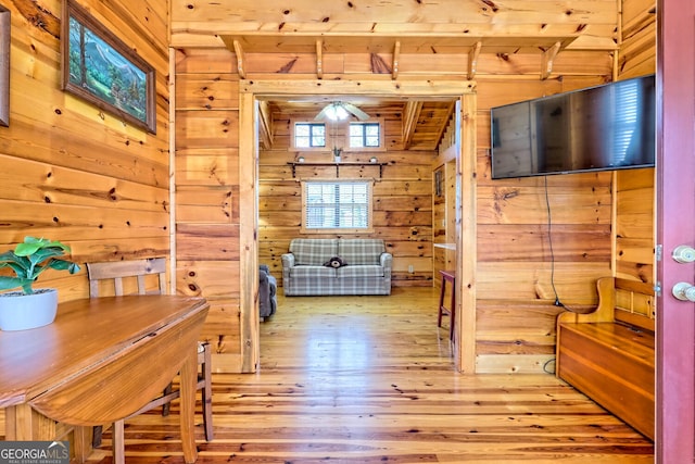 interior space with light wood-type flooring, wooden walls, and wooden ceiling