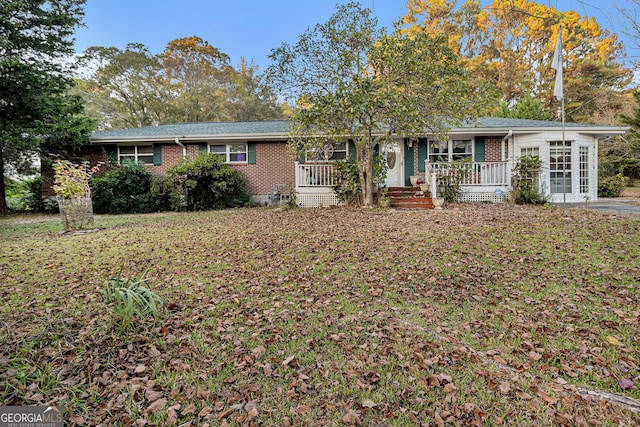 ranch-style home featuring a front yard and covered porch