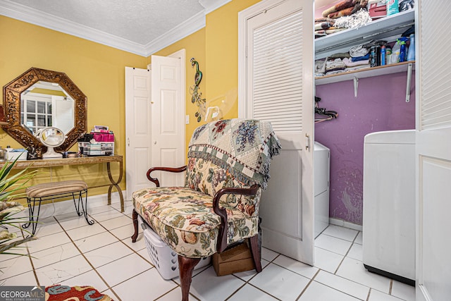 sitting room featuring light tile patterned flooring, washer and dryer, a textured ceiling, and ornamental molding