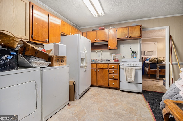 kitchen featuring a textured ceiling, sink, crown molding, white appliances, and washer and dryer