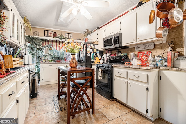 kitchen with gas stove, white cabinetry, ceiling fan, and crown molding