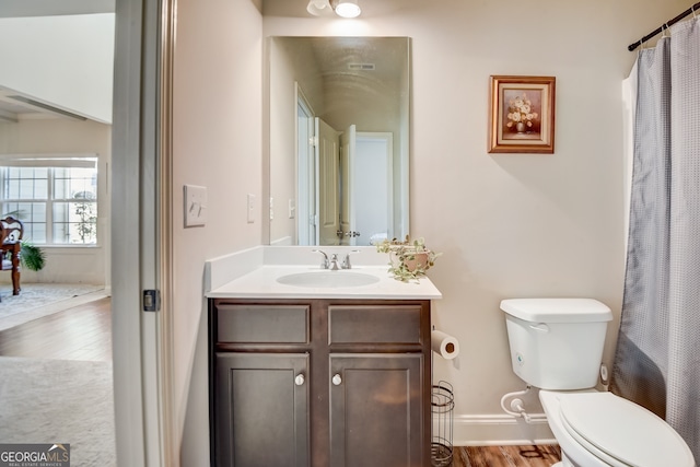 bathroom with toilet, vanity, and wood-type flooring