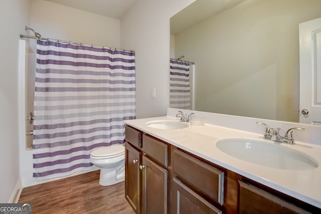 full bathroom with shower / bath combo with shower curtain, vanity, hardwood / wood-style flooring, and toilet