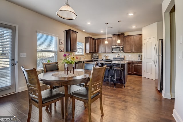 dining space with dark hardwood / wood-style flooring