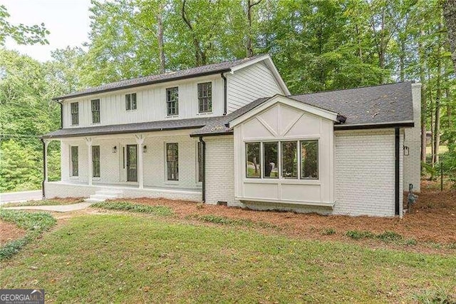 view of front of home with covered porch and a front lawn