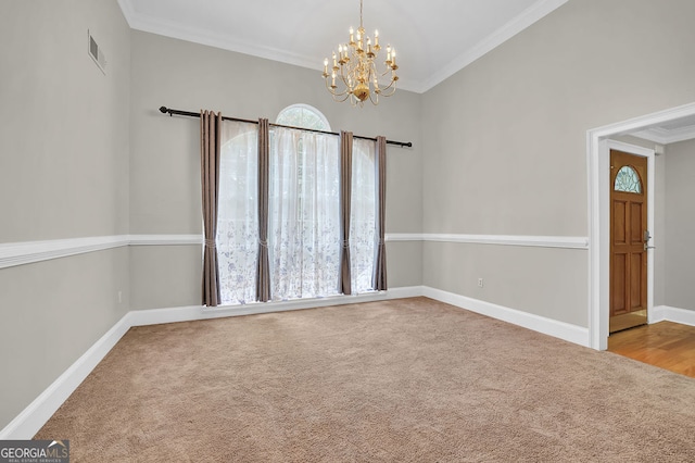 carpeted spare room featuring a chandelier and crown molding