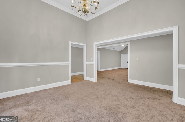 empty room featuring light colored carpet, high vaulted ceiling, an inviting chandelier, and crown molding