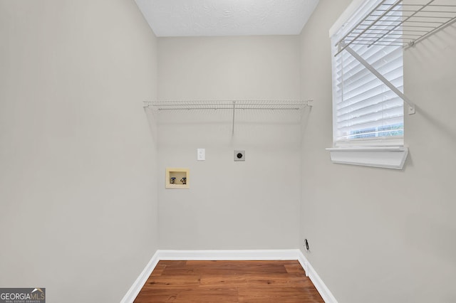 laundry area featuring hardwood / wood-style flooring, a textured ceiling, electric dryer hookup, and washer hookup