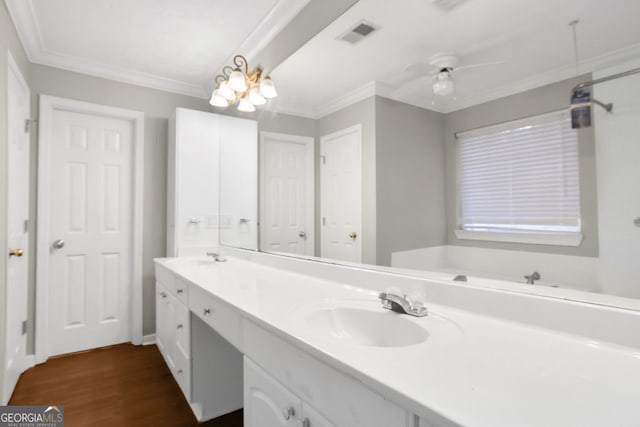 bathroom featuring ceiling fan, vanity, wood-type flooring, and ornamental molding