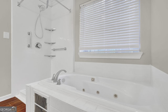 bathroom with hardwood / wood-style flooring and independent shower and bath