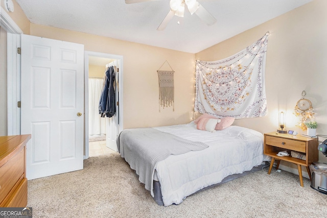 bedroom featuring a spacious closet, ceiling fan, and carpet