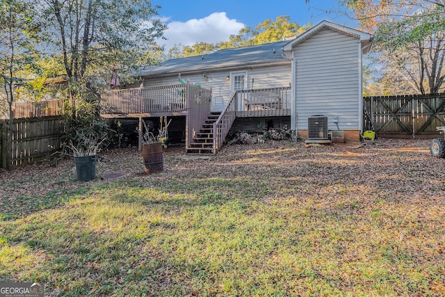 back of property with central air condition unit, a fenced backyard, stairway, and a deck