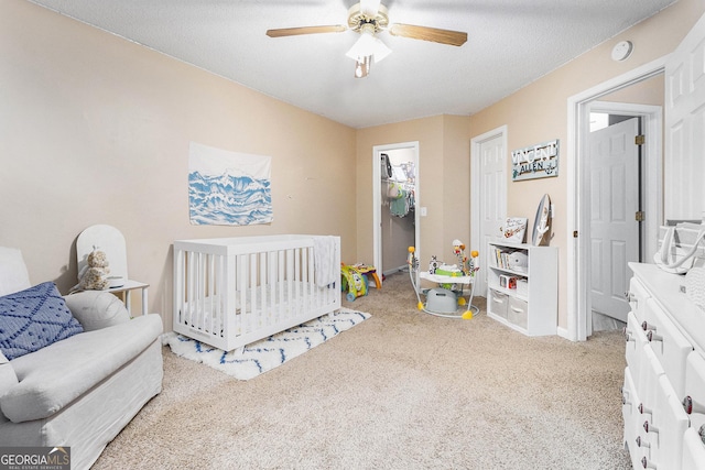 carpeted bedroom with a textured ceiling and a ceiling fan