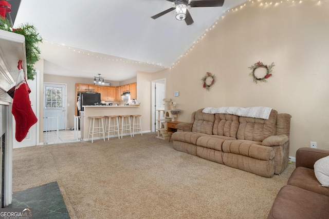 living room with light colored carpet, vaulted ceiling, baseboards, and ceiling fan