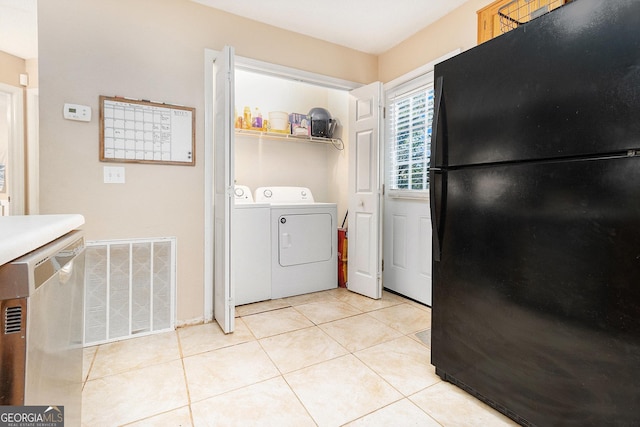 washroom with laundry area, visible vents, washer and clothes dryer, and light tile patterned floors