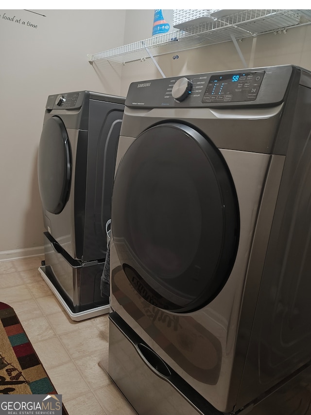 clothes washing area with laundry area, independent washer and dryer, and baseboards