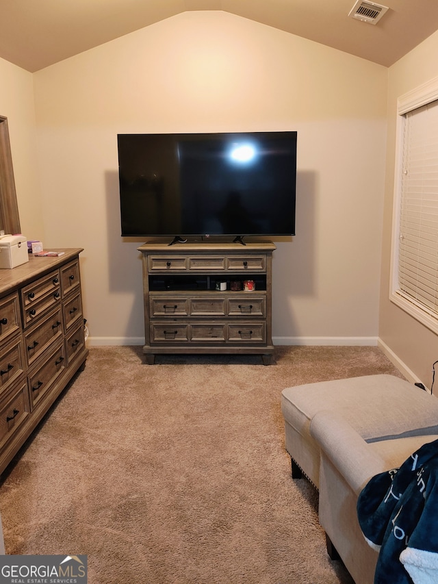 living room featuring light carpet, lofted ceiling, visible vents, and baseboards