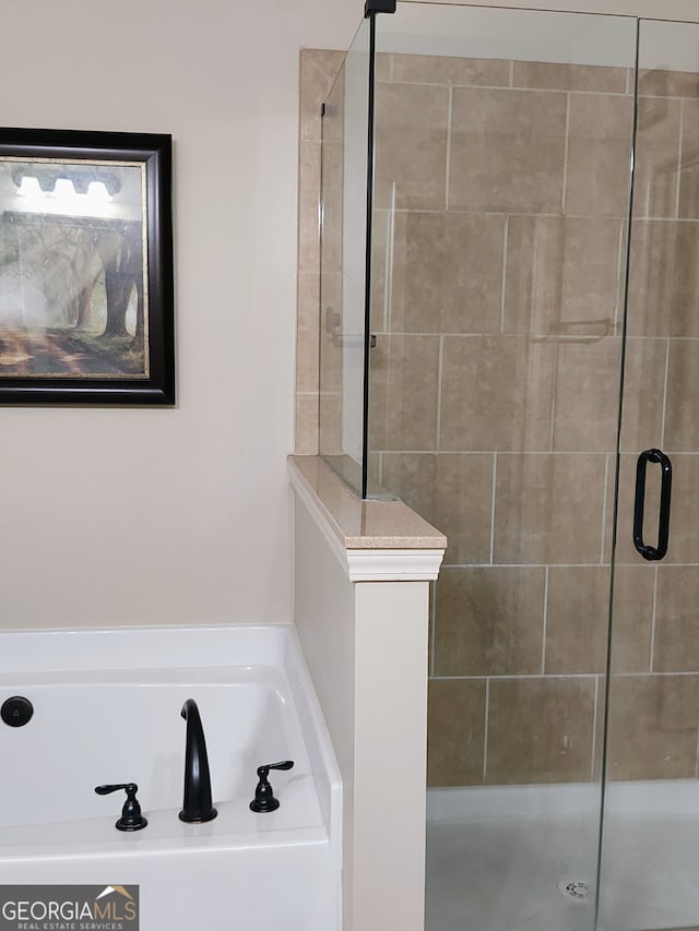 bathroom featuring a garden tub and a tile shower