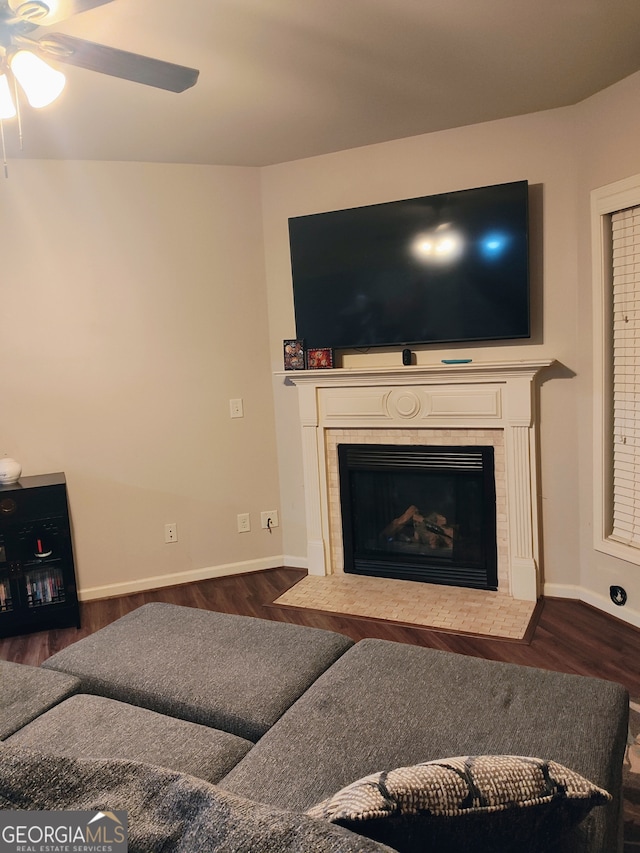 living area with dark wood-style flooring, a fireplace, baseboards, and ceiling fan