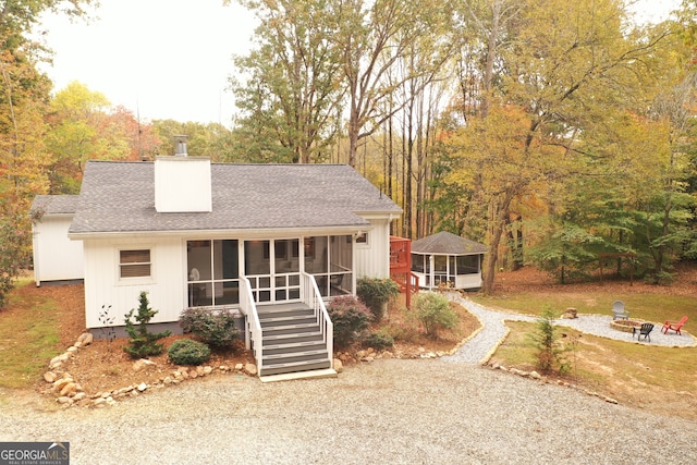 view of front of house featuring a fire pit and a sunroom