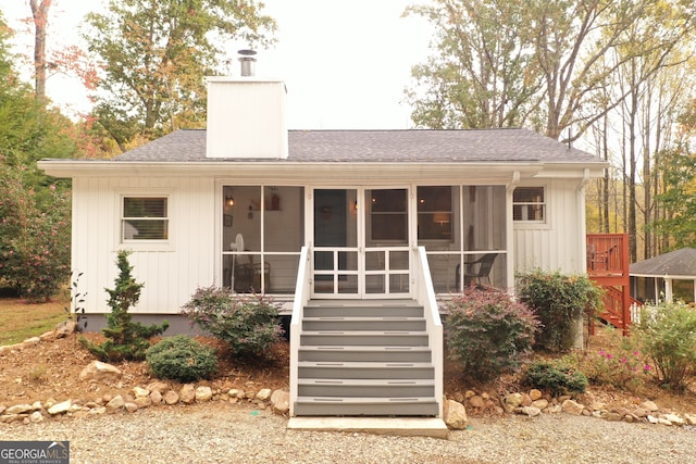 rear view of house featuring a sunroom