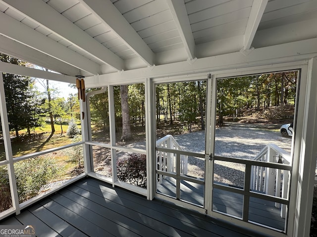 unfurnished sunroom with plenty of natural light, beam ceiling, and wooden ceiling