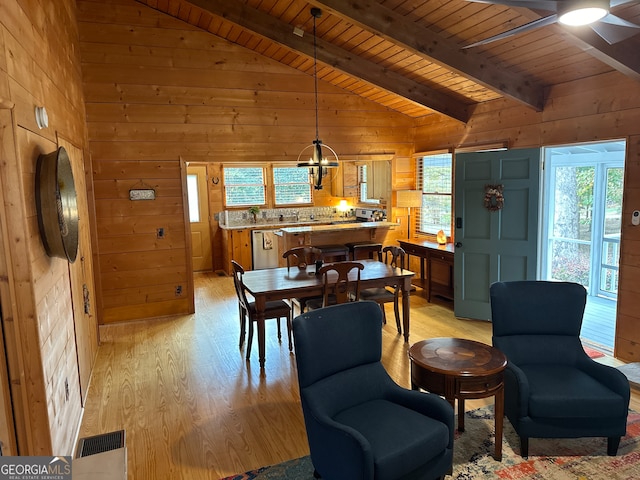 dining area with ceiling fan, wooden walls, lofted ceiling with beams, light hardwood / wood-style flooring, and wooden ceiling