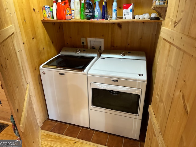 washroom featuring hardwood / wood-style flooring, washer and dryer, and wood walls