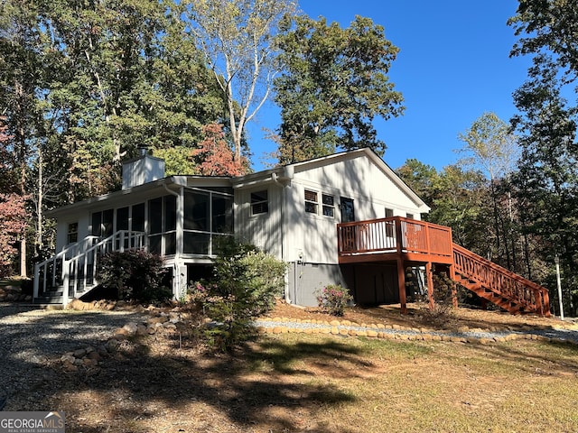 exterior space with a wooden deck and a sunroom