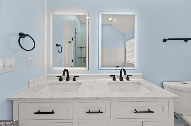 bathroom with a shower with door, vanity, toilet, and vaulted ceiling