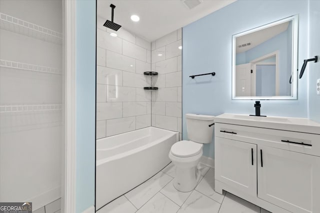 full bathroom featuring tiled shower / bath, vanity, and toilet