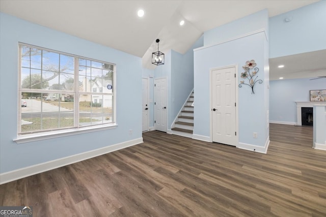 interior space with dark hardwood / wood-style flooring, a chandelier, and vaulted ceiling