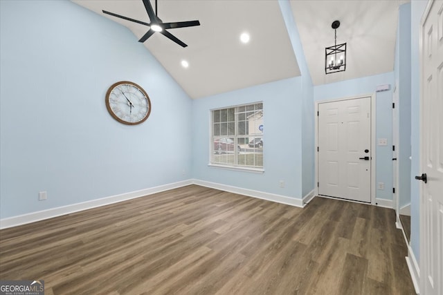 entryway featuring ceiling fan with notable chandelier, dark wood-type flooring, and high vaulted ceiling