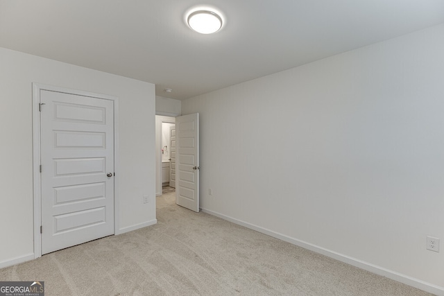 unfurnished bedroom with light carpet and a closet