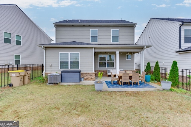 rear view of house featuring a lawn, a patio, and central AC