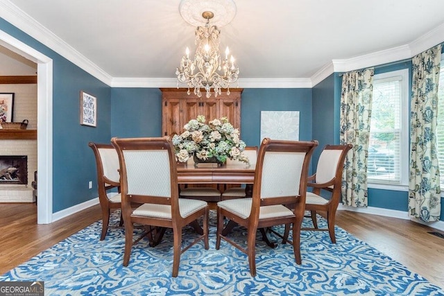 dining area with a fireplace, wood-type flooring, and ornamental molding