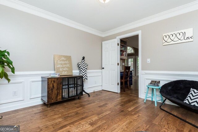 sitting room with dark hardwood / wood-style floors and crown molding