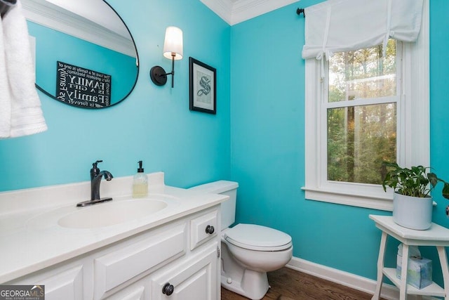 bathroom with hardwood / wood-style flooring, vanity, toilet, and ornamental molding