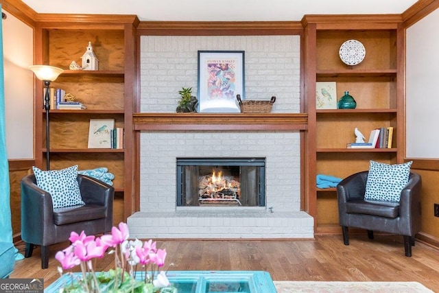 living area with light hardwood / wood-style floors and a brick fireplace