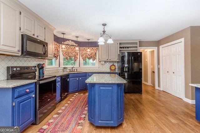 kitchen featuring black appliances, an inviting chandelier, blue cabinetry, a kitchen island, and pendant lighting