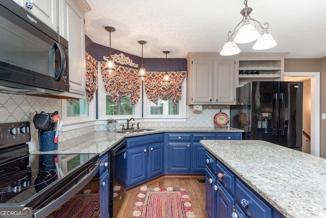 kitchen featuring blue cabinetry, black appliances, and decorative light fixtures