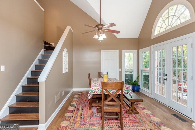 dining space with french doors, ceiling fan, light hardwood / wood-style floors, and high vaulted ceiling