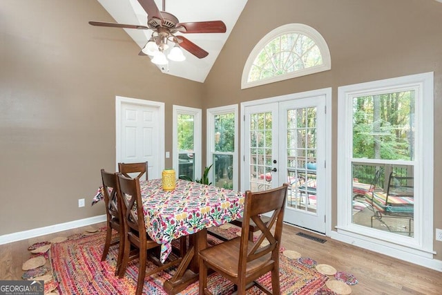 dining space featuring high vaulted ceiling, light wood-type flooring, french doors, and ceiling fan