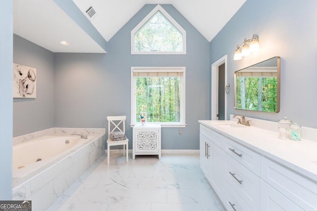 bathroom with high vaulted ceiling, vanity, and tiled tub